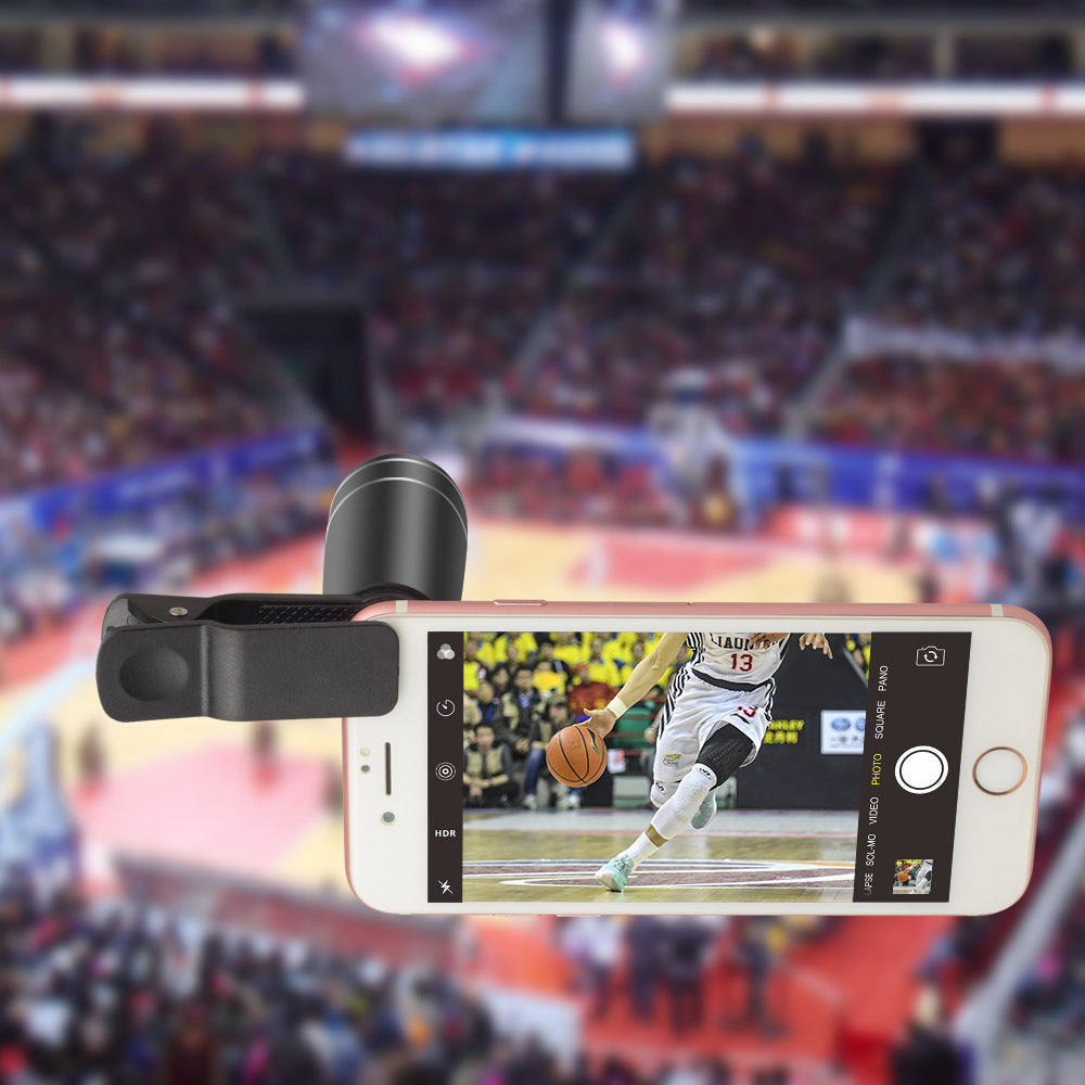 Smartphone with a camera lens attachment displaying a basketball game in an arena.