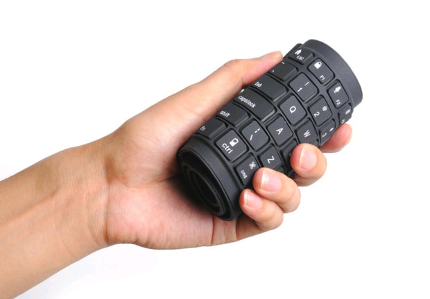 Bluetooth folding silicone keyboard held in a hand, showcasing its portable and flexible design.