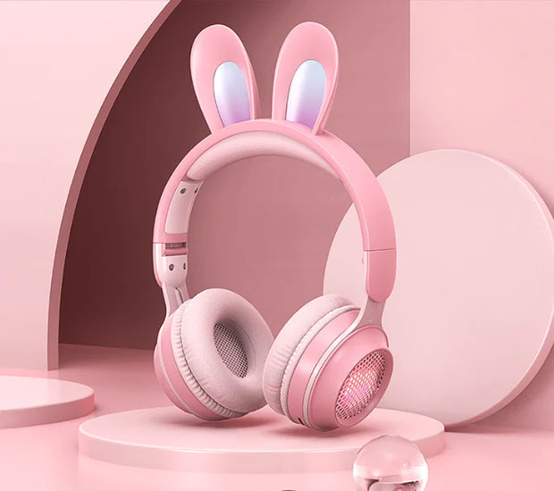 Charming Bunny Ear Headphones in pink with rabbit ears and soft cushions on a pink background.