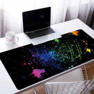 Custom Large Gaming Mouse Pad with colorful splash design on a desk alongside a laptop and mug.