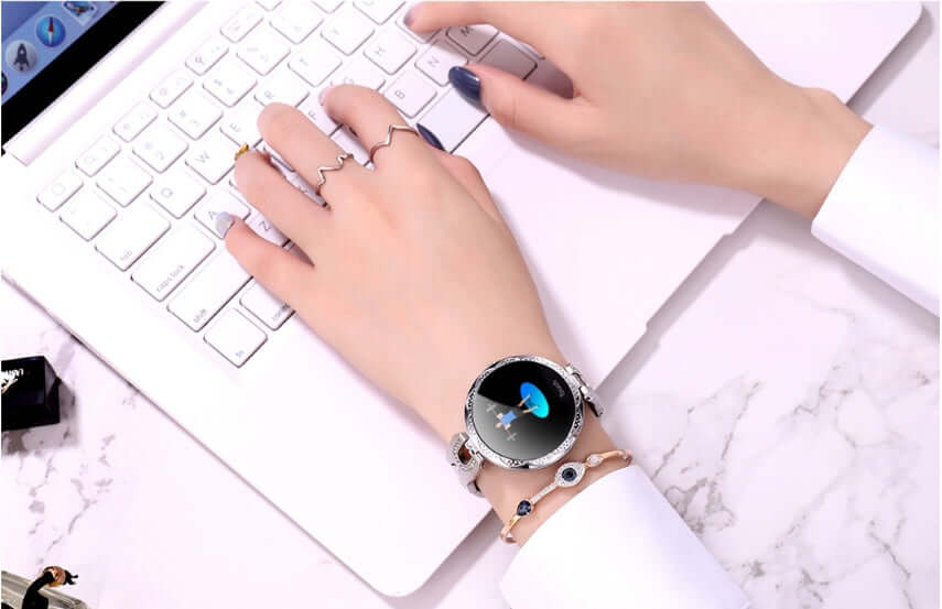 Fashionable Women's Smart Watch on a woman's wrist while typing on a laptop, showcasing style and technology.