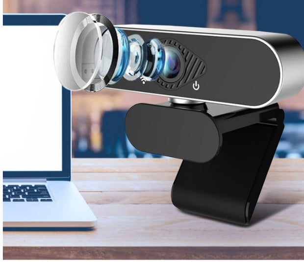 Webcam with microphone showcasing its detailed lens setup next to a laptop for video calls.