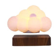 Glowing Cloud Light with soft white glow on a wooden base, creating a dreamy atmosphere in any room.