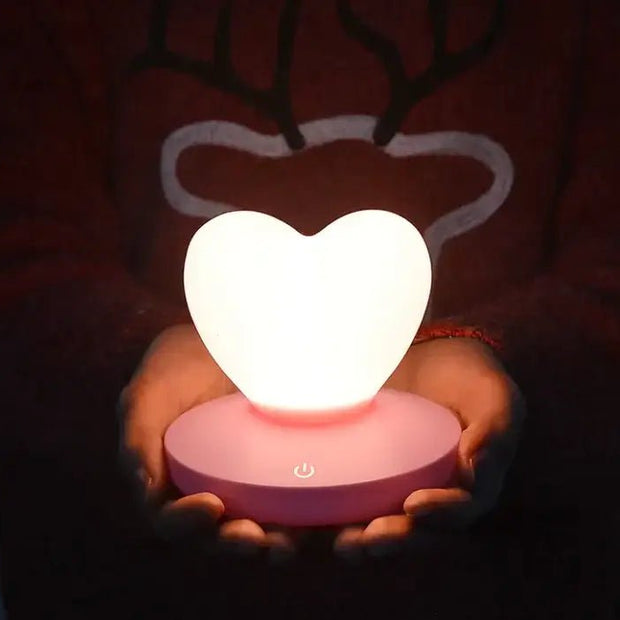 GlowTouch Desk Lamp featuring a heart-shaped light held by hands, providing soft illumination and modern charm.