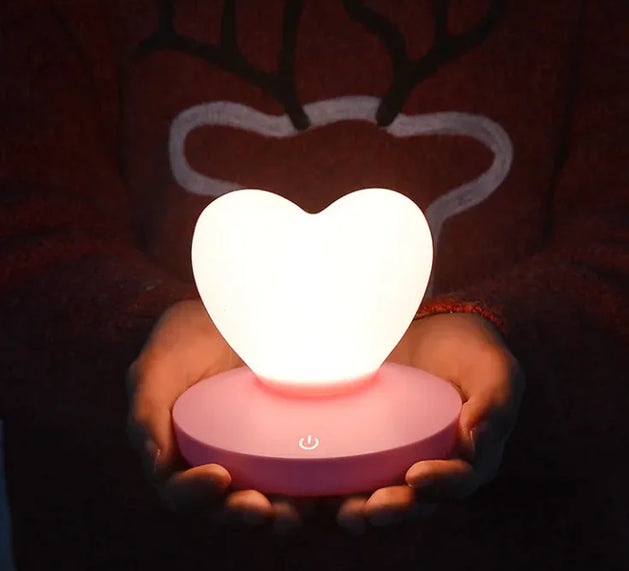 GlowTouch Desk Lamp featuring a heart-shaped light held by hands, providing soft illumination and modern charm.