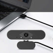 Webcam with microphone connected to a laptop, ideal for video calls and online meetings.